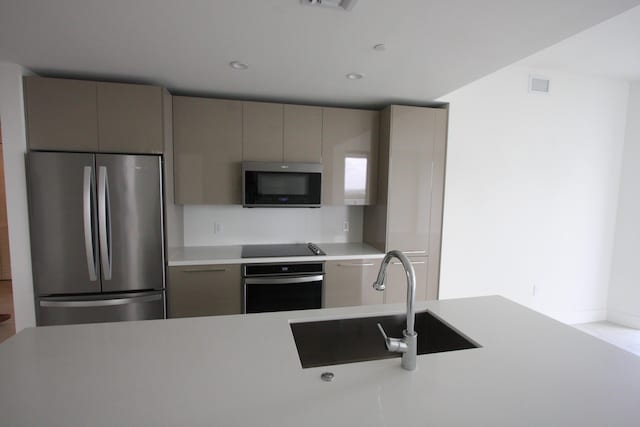 kitchen featuring sink, stainless steel appliances, and gray cabinetry