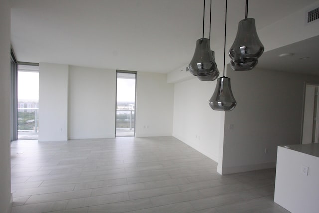 unfurnished living room with a wall of windows and light hardwood / wood-style flooring