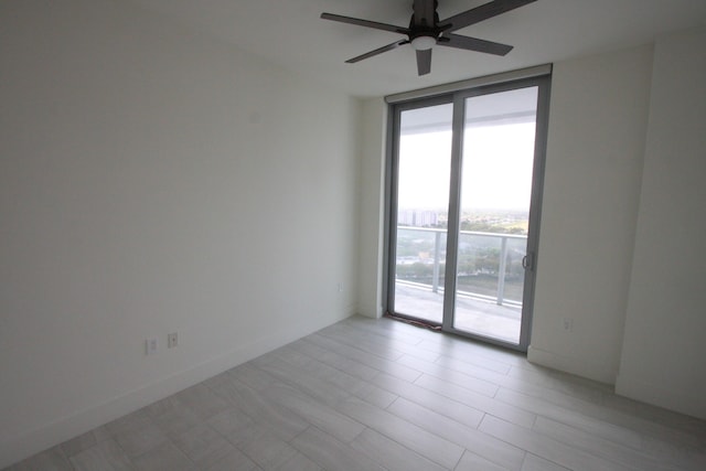 empty room with ceiling fan and expansive windows