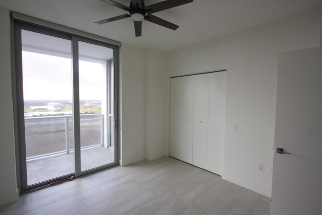 unfurnished bedroom with ceiling fan, access to exterior, a closet, and floor to ceiling windows