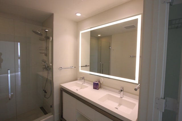 bathroom featuring vanity and a shower with door