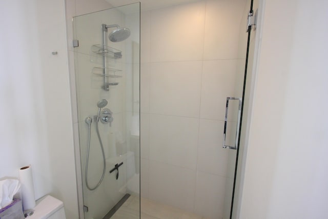 bathroom featuring an enclosed shower and toilet