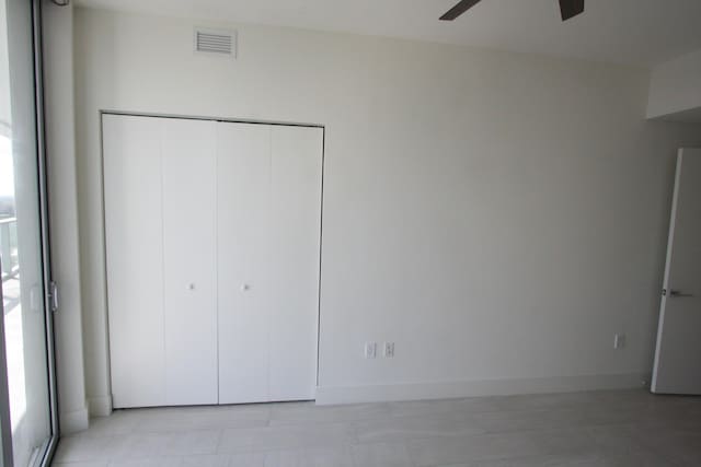 unfurnished bedroom with ceiling fan, multiple windows, and a closet