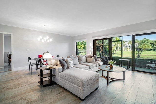 living room featuring crown molding, a chandelier, and light hardwood / wood-style flooring