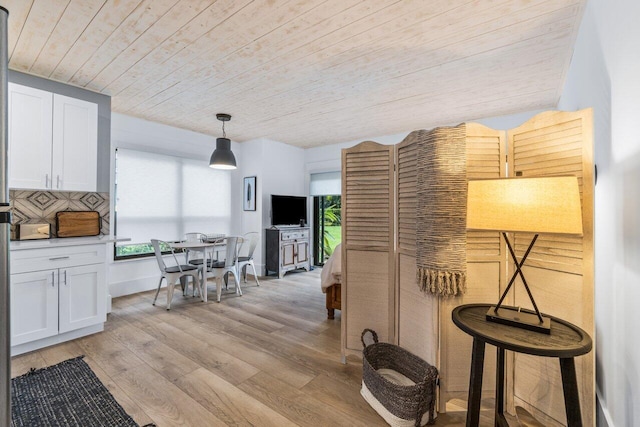 corridor with light hardwood / wood-style flooring and wooden ceiling