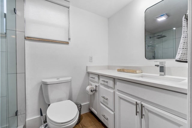 bathroom featuring vanity, wood-type flooring, a shower with door, and toilet