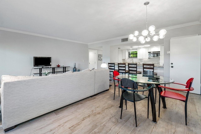 dining room with crown molding, an inviting chandelier, and light wood-type flooring