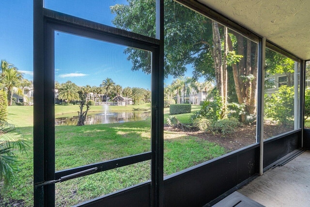 unfurnished sunroom featuring a water view