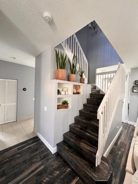 stairs with hardwood / wood-style floors and a textured ceiling