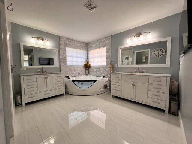 bathroom featuring tile patterned floors, vanity, and a tub