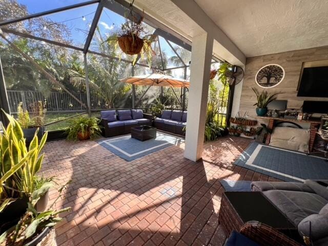 view of patio / terrace featuring glass enclosure and an outdoor living space with a fire pit