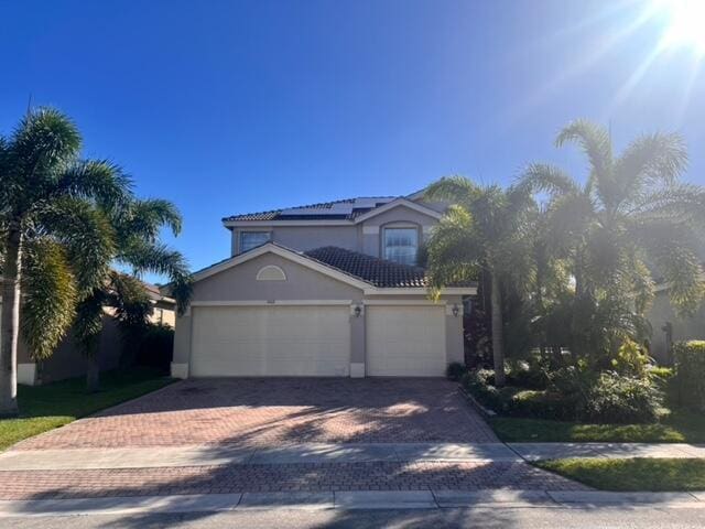 view of front facade with a garage and solar panels