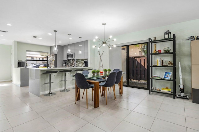 tiled dining space featuring an inviting chandelier