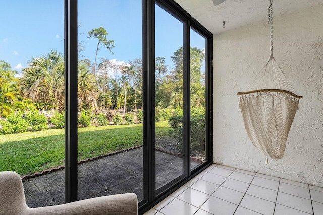 doorway to outside with expansive windows and light tile patterned flooring