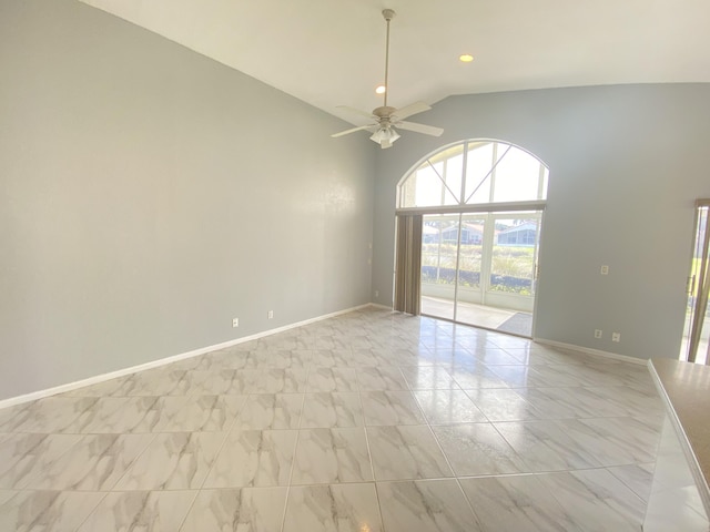 spare room with high vaulted ceiling, a ceiling fan, and baseboards