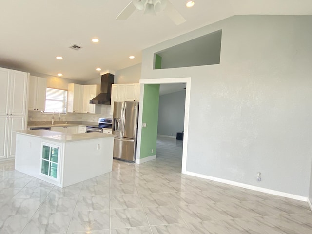 kitchen featuring visible vents, stainless steel appliances, vaulted ceiling, wall chimney range hood, and tasteful backsplash