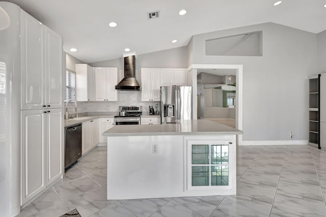 kitchen with marble finish floor, appliances with stainless steel finishes, wall chimney exhaust hood, and lofted ceiling