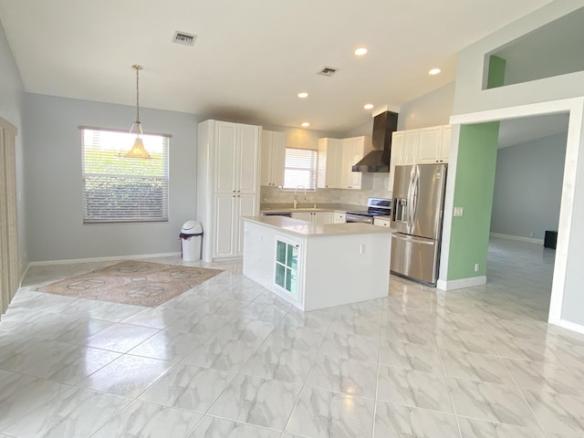 kitchen featuring visible vents, stainless steel appliances, light countertops, wall chimney range hood, and a center island