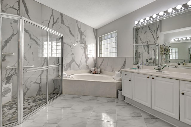 full bath featuring a garden tub, marble finish floor, a textured ceiling, a marble finish shower, and vanity