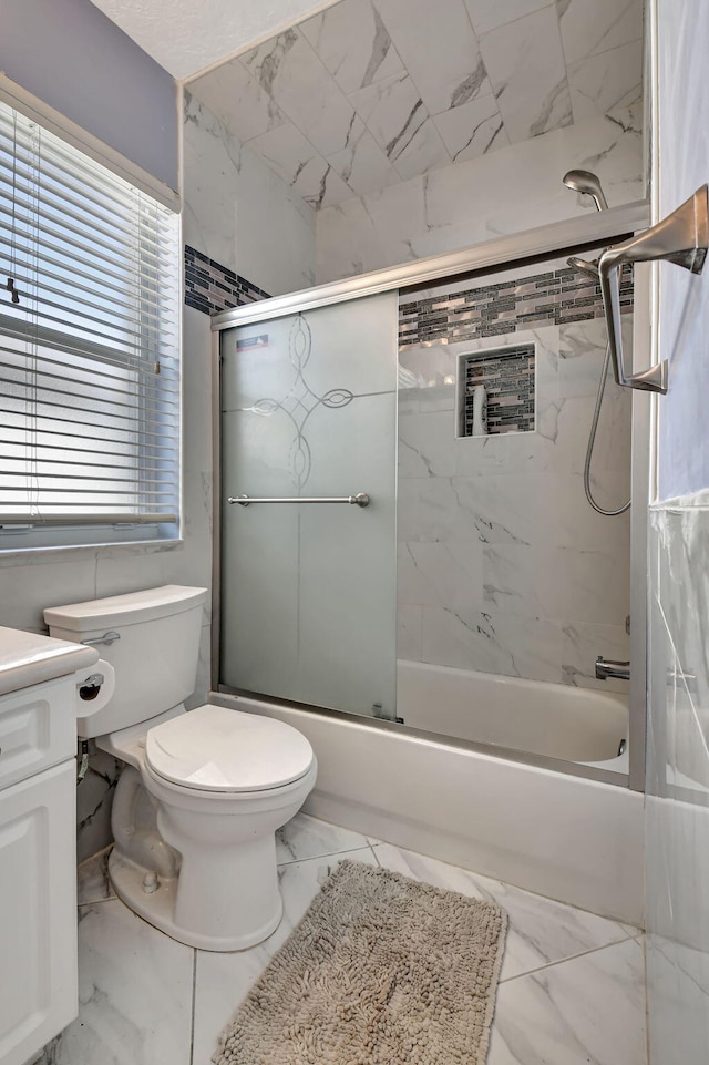 full bathroom featuring vanity, toilet, marble finish floor, and bath / shower combo with glass door