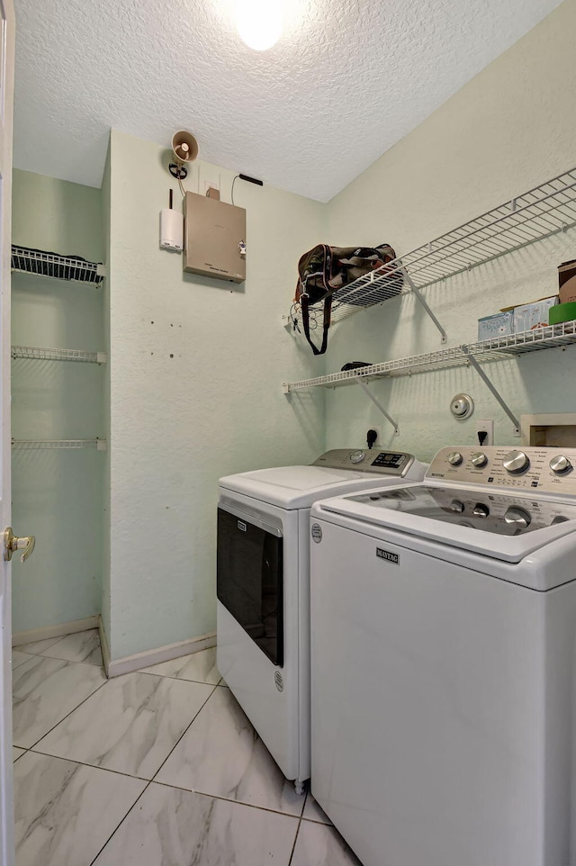 washroom with baseboards, laundry area, separate washer and dryer, a textured ceiling, and marble finish floor