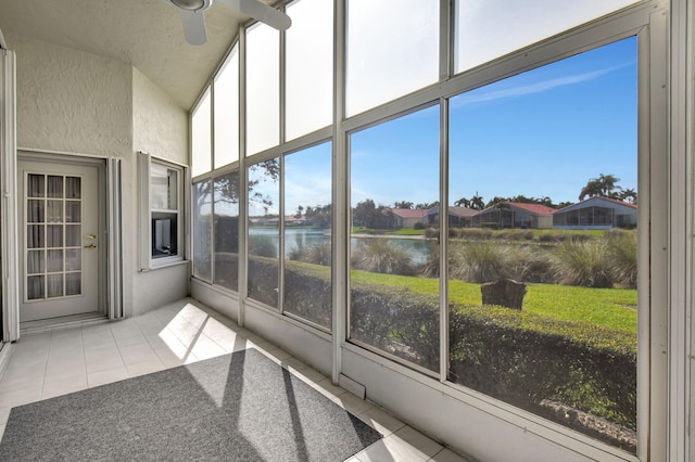 sunroom featuring a water view and ceiling fan