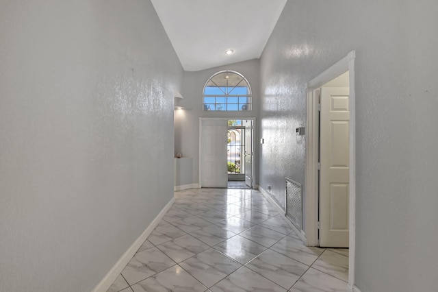 entrance foyer featuring visible vents, marble finish floor, baseboards, and a towering ceiling