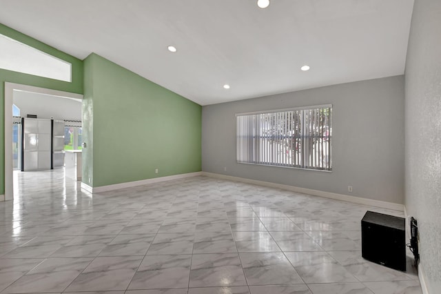 spare room featuring lofted ceiling, recessed lighting, baseboards, and marble finish floor