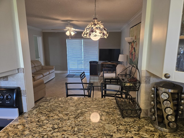 tiled dining area with crown molding, ceiling fan, and a textured ceiling