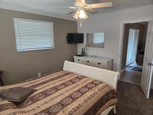 bedroom featuring dark tile patterned floors, ornamental molding, and ceiling fan