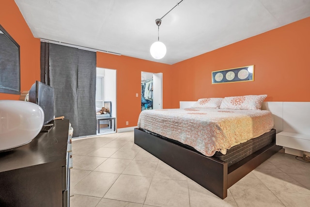 tiled bedroom with a closet and a walk in closet