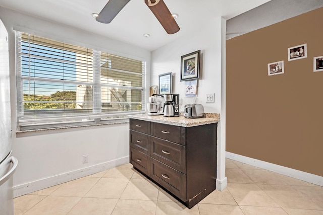 kitchen with ceiling fan, dark brown cabinetry, and light tile patterned floors