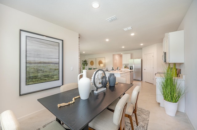 dining space with light tile patterned floors and sink