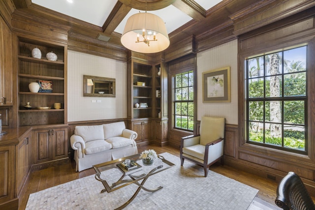 living area featuring built in shelves, dark hardwood / wood-style flooring, and a wealth of natural light