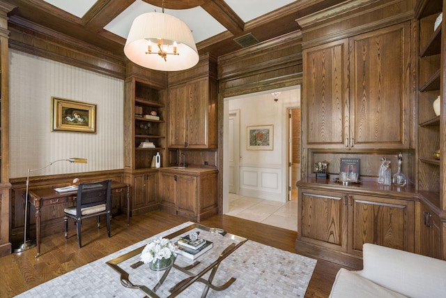 office featuring beamed ceiling, coffered ceiling, light hardwood / wood-style flooring, an inviting chandelier, and built in features