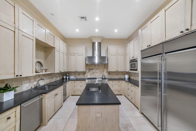 kitchen with a center island, tasteful backsplash, sink, stainless steel appliances, and wall chimney exhaust hood