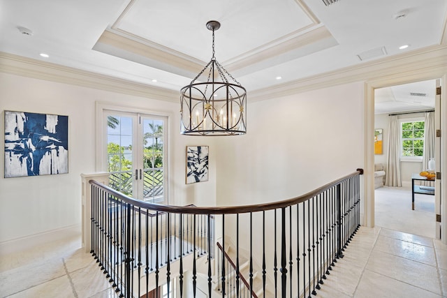 hallway with crown molding, a raised ceiling, and french doors