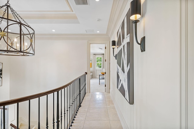 hall featuring light tile patterned floors, ornamental molding, and a chandelier