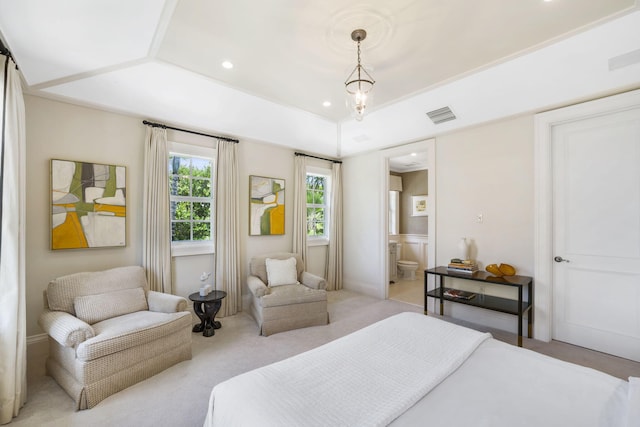 bedroom featuring a tray ceiling, ensuite bathroom, and light carpet