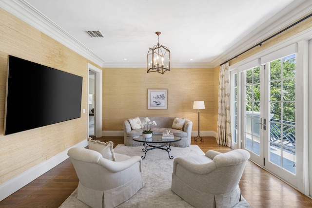 living room with a notable chandelier, french doors, hardwood / wood-style floors, and ornamental molding