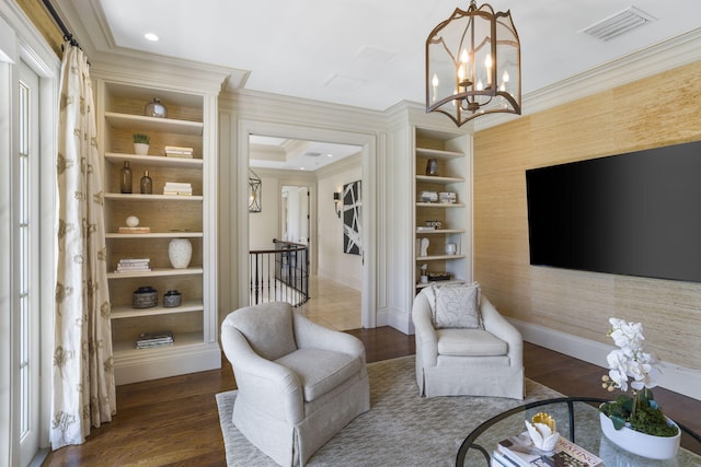 sitting room with dark wood-type flooring, built in features, crown molding, and a notable chandelier