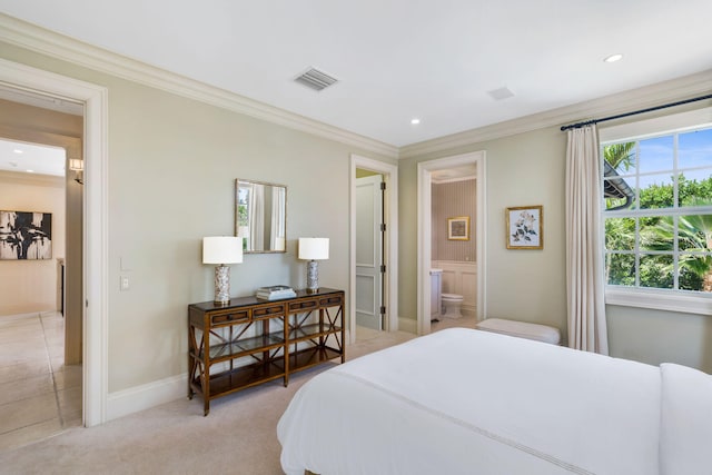 bedroom featuring ornamental molding, light carpet, and ensuite bath