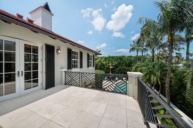 view of patio featuring a balcony and french doors