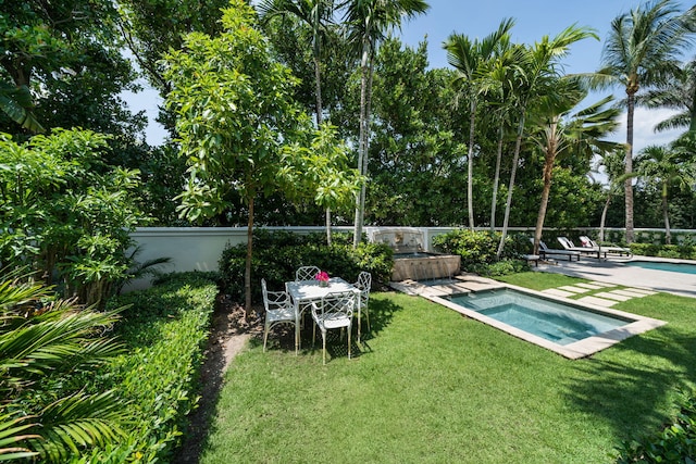 view of pool featuring an outdoor hot tub, a lawn, and a patio