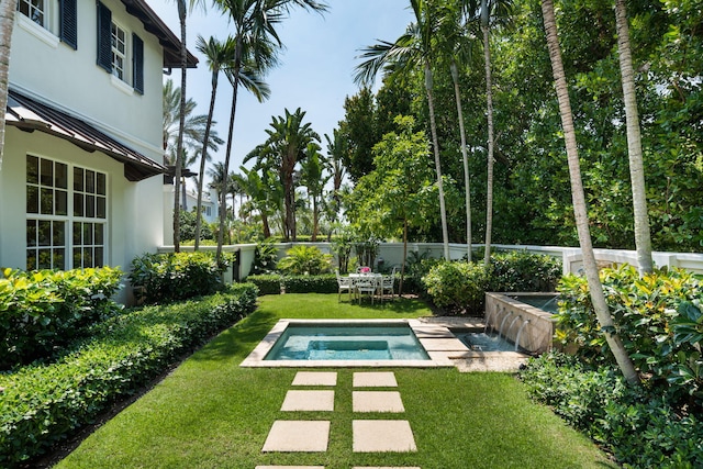 view of swimming pool featuring a hot tub and a yard