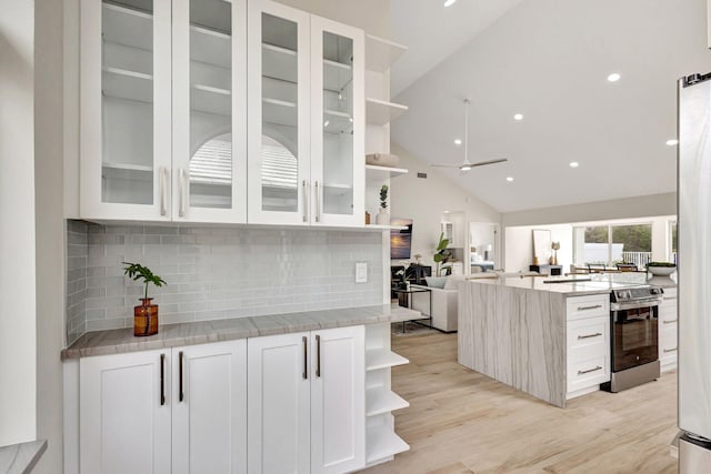 kitchen with white cabinetry, stainless steel electric range oven, light stone countertops, and backsplash