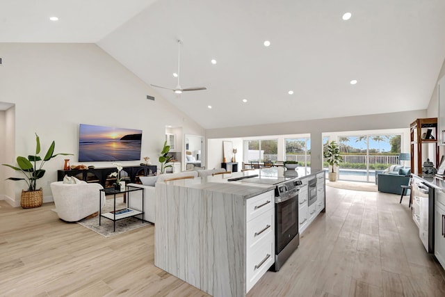 kitchen featuring a kitchen island, high vaulted ceiling, white cabinets, stainless steel appliances, and light hardwood / wood-style flooring