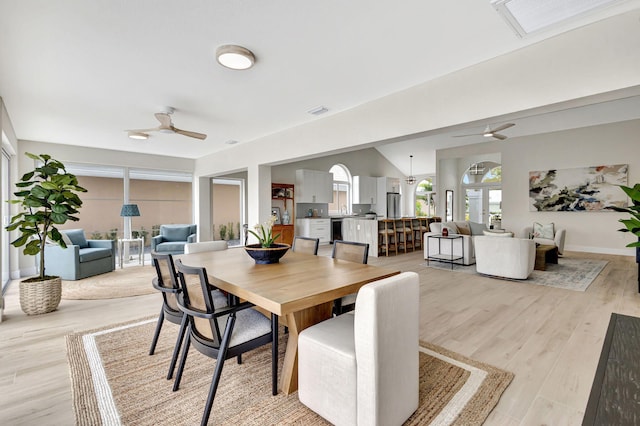 dining space with light hardwood / wood-style floors and ceiling fan