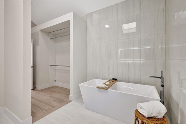 bathroom with a bath and tile walls