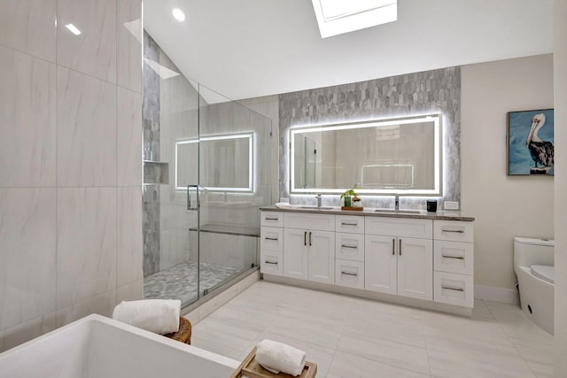 full bathroom with toilet, shower with separate bathtub, a skylight, tile walls, and vanity